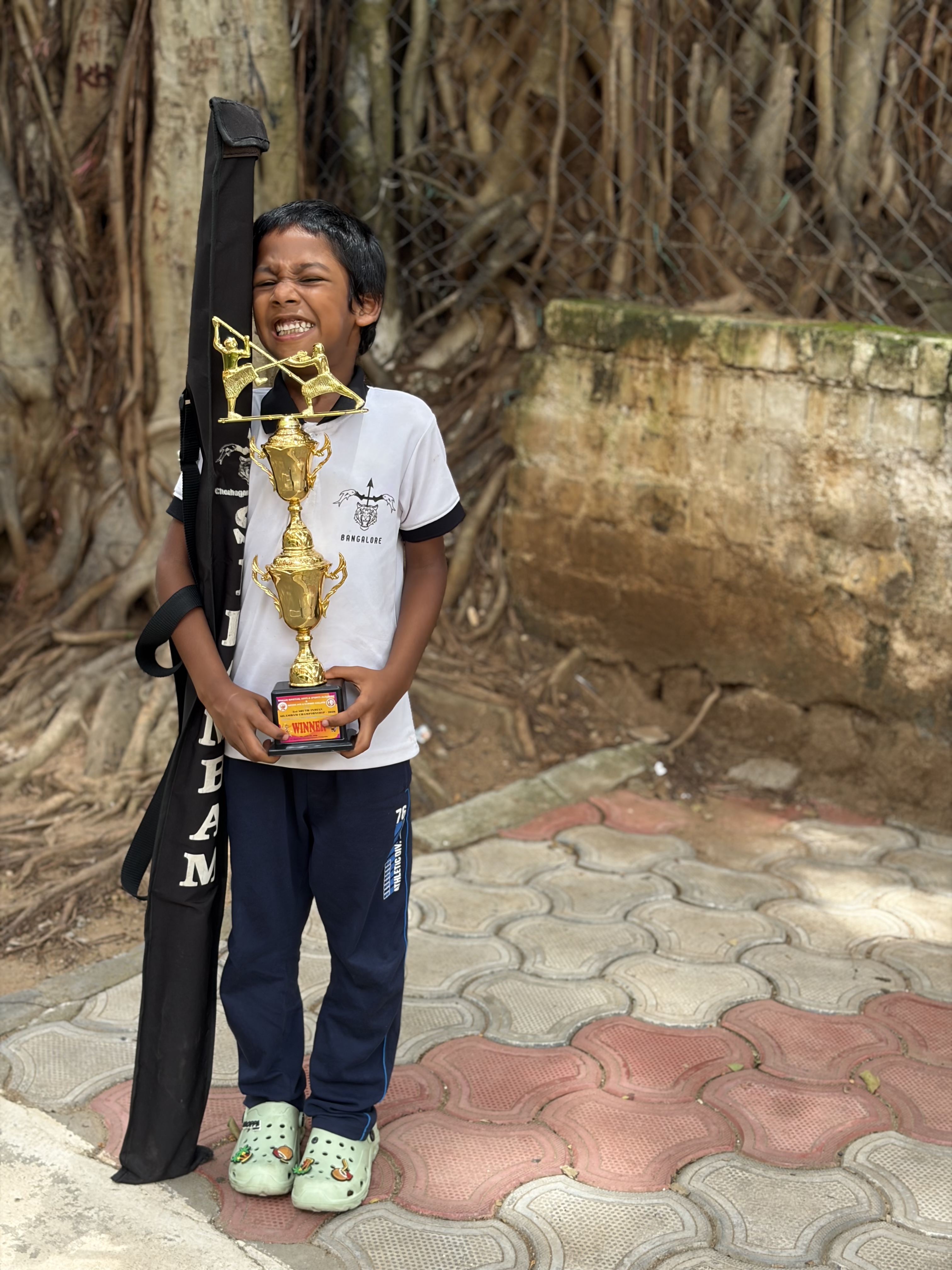 Prithvi laughing with delight while holding his trophy